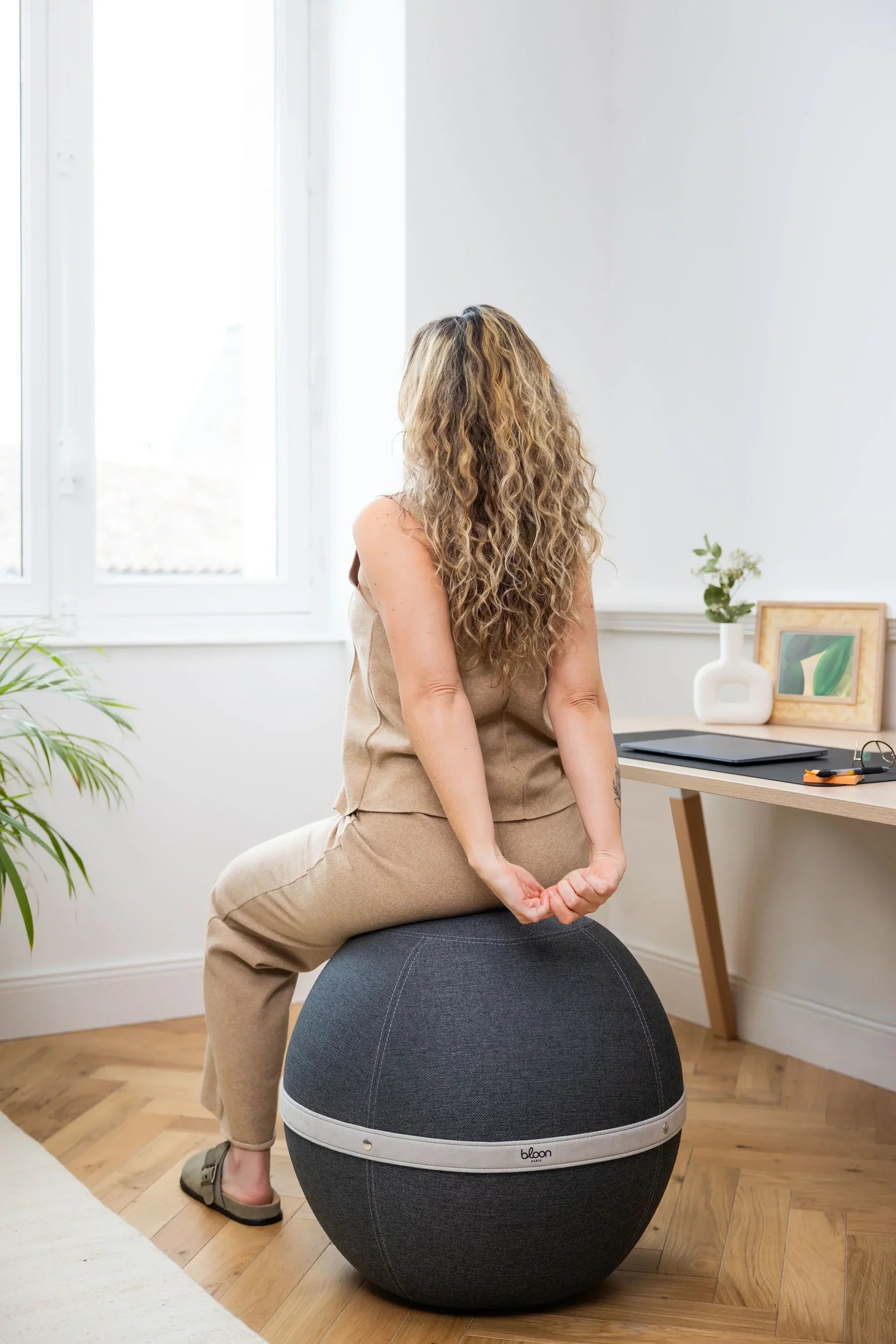 Best stretches to do at work. Woman sitting and stretching on a Bloon ball seat