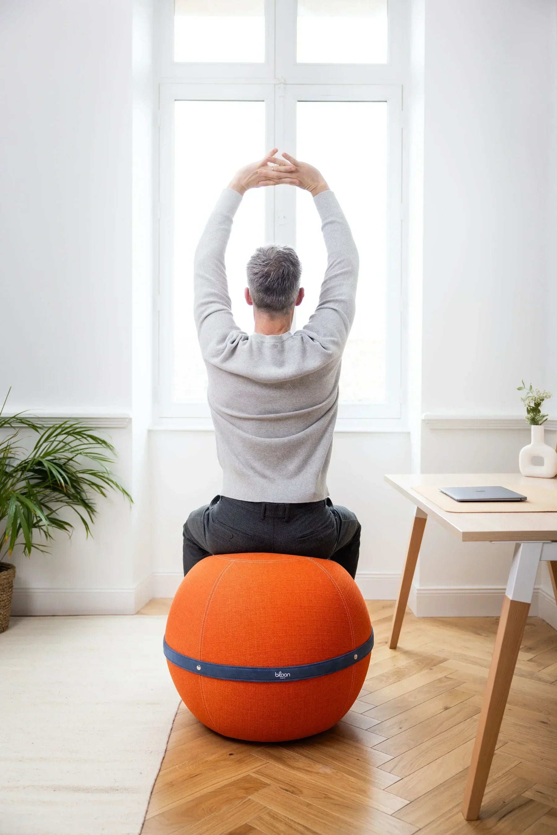 Dynamic sitting. Man sitting on a Bloon ball seat doing some stretches