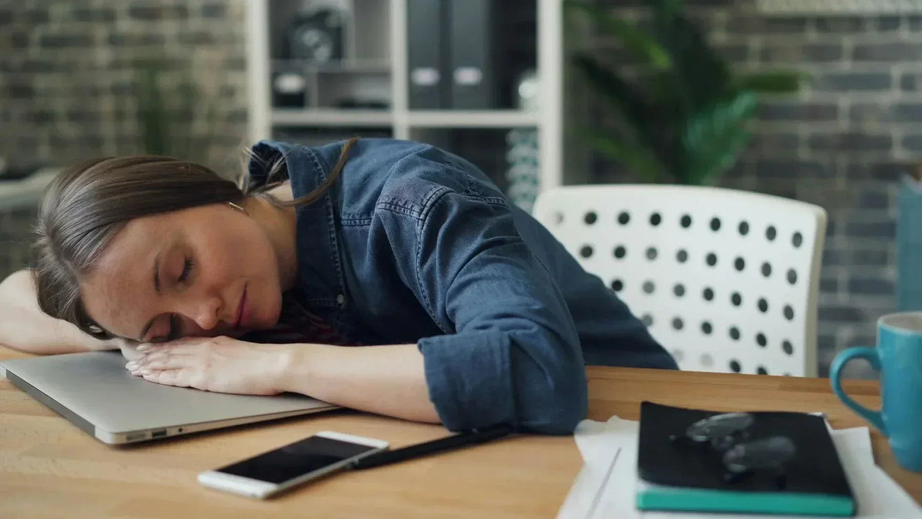 Workplace napping : benefits and risks. A woman taking a nap sitting at her desk